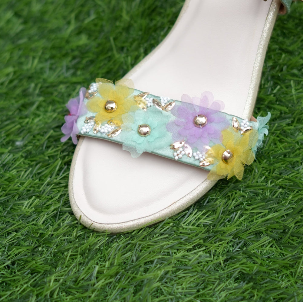Decorative sandal with floral straps on a grass background