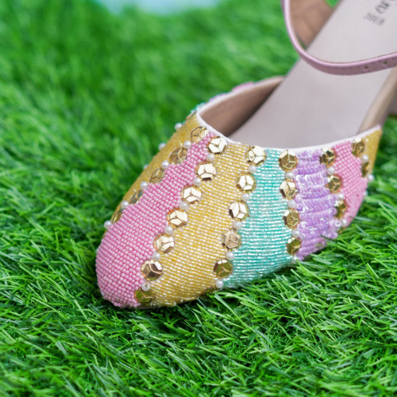 Colorful beaded shoe on a grassy surface