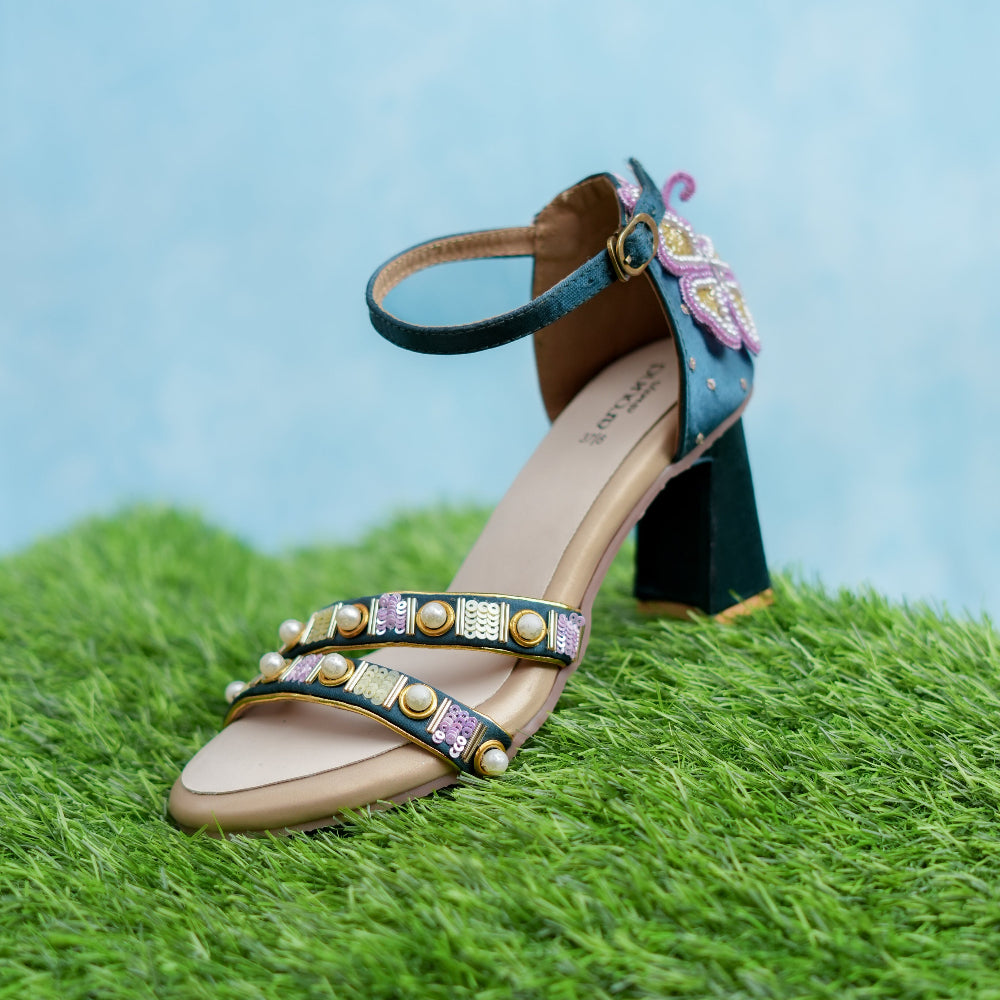 Decorative sandal with floral embellishments on a grassy surface
