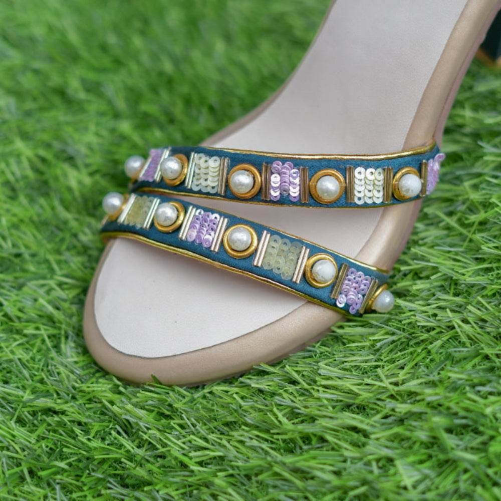 Decorative sandal with beaded strap on a grass background