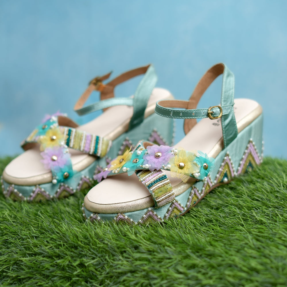 Turquoise wedge sandals with floral embellishments and multicolour handcrafted detailing.