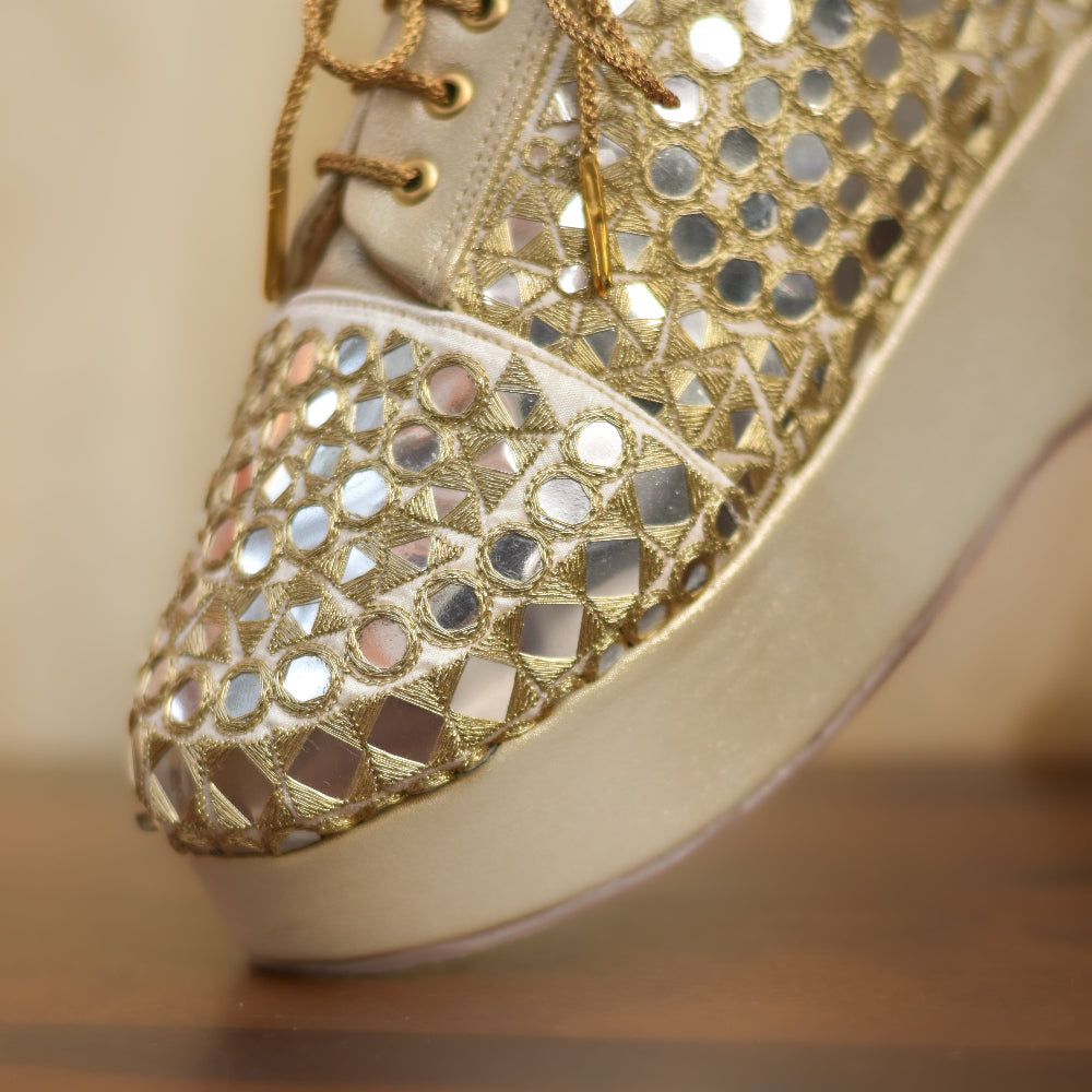 Bridal sneaker wedges with gold finish, mirror pattern surface, and raised heel for comfort
