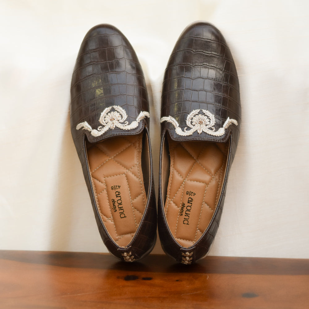 Elegant brown shoes with embossed finish and fine stitched work.