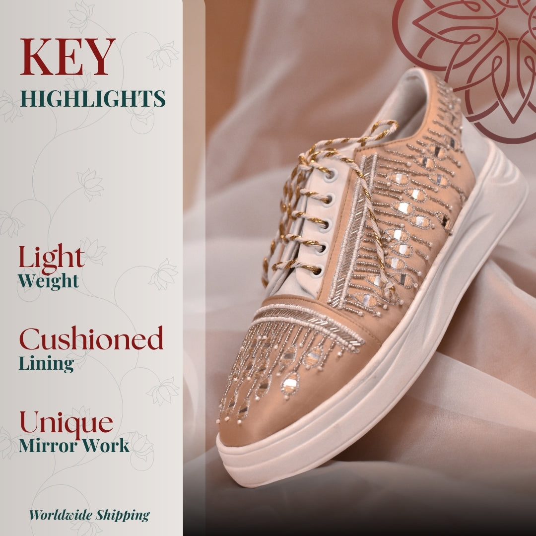 Beige sneaker with intricate mirror work and bead embroidery and cushioned white sole for a lightweight festive look.