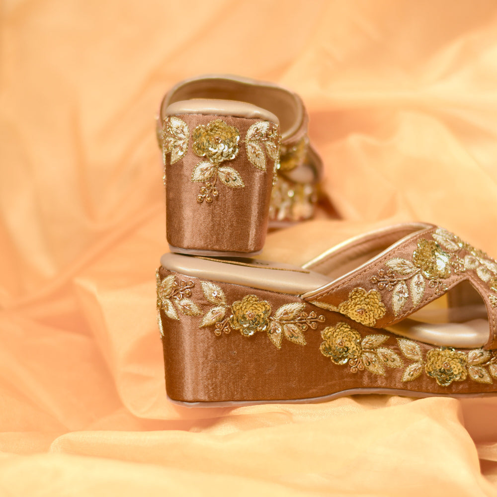 Gold wedges with ornate floral craftsmanship and platform heel