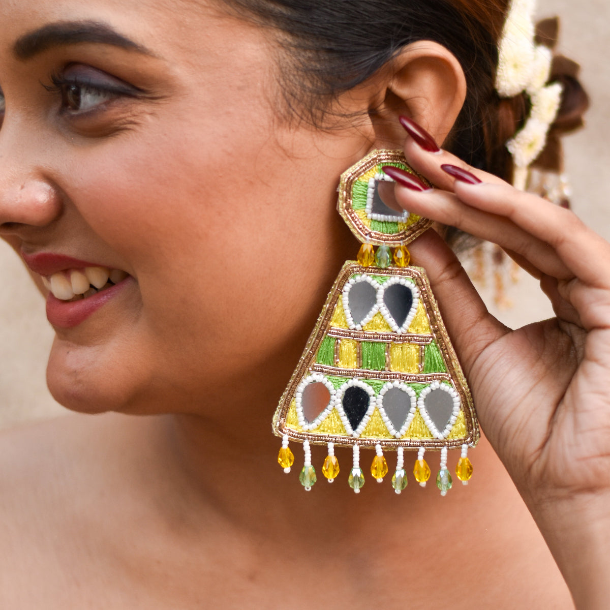 Woman wearing a colorful yellow green beaded earring for a wedding look
