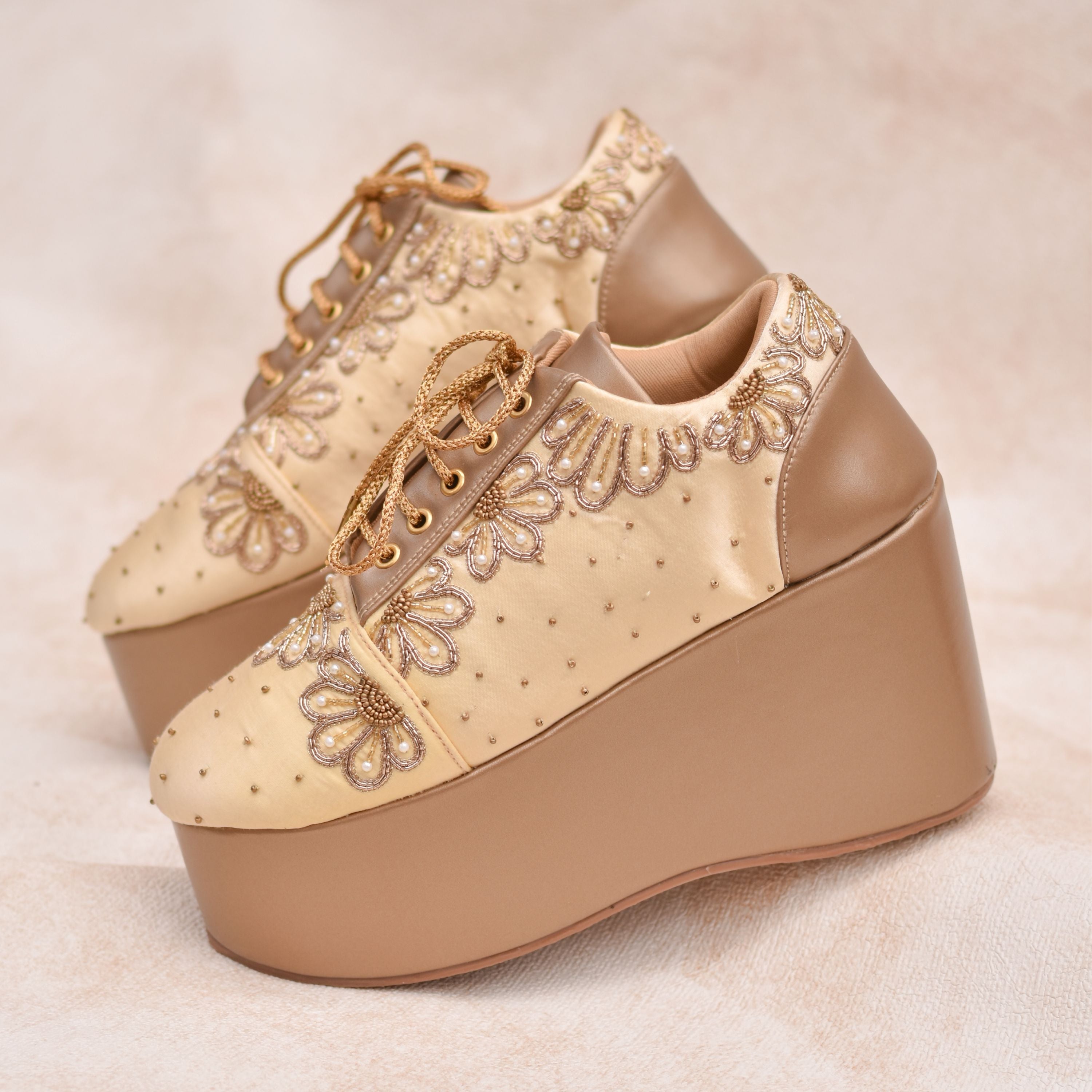 Bridal wedge sneaker in gold with floral embroidery and cushioned comfort sole.