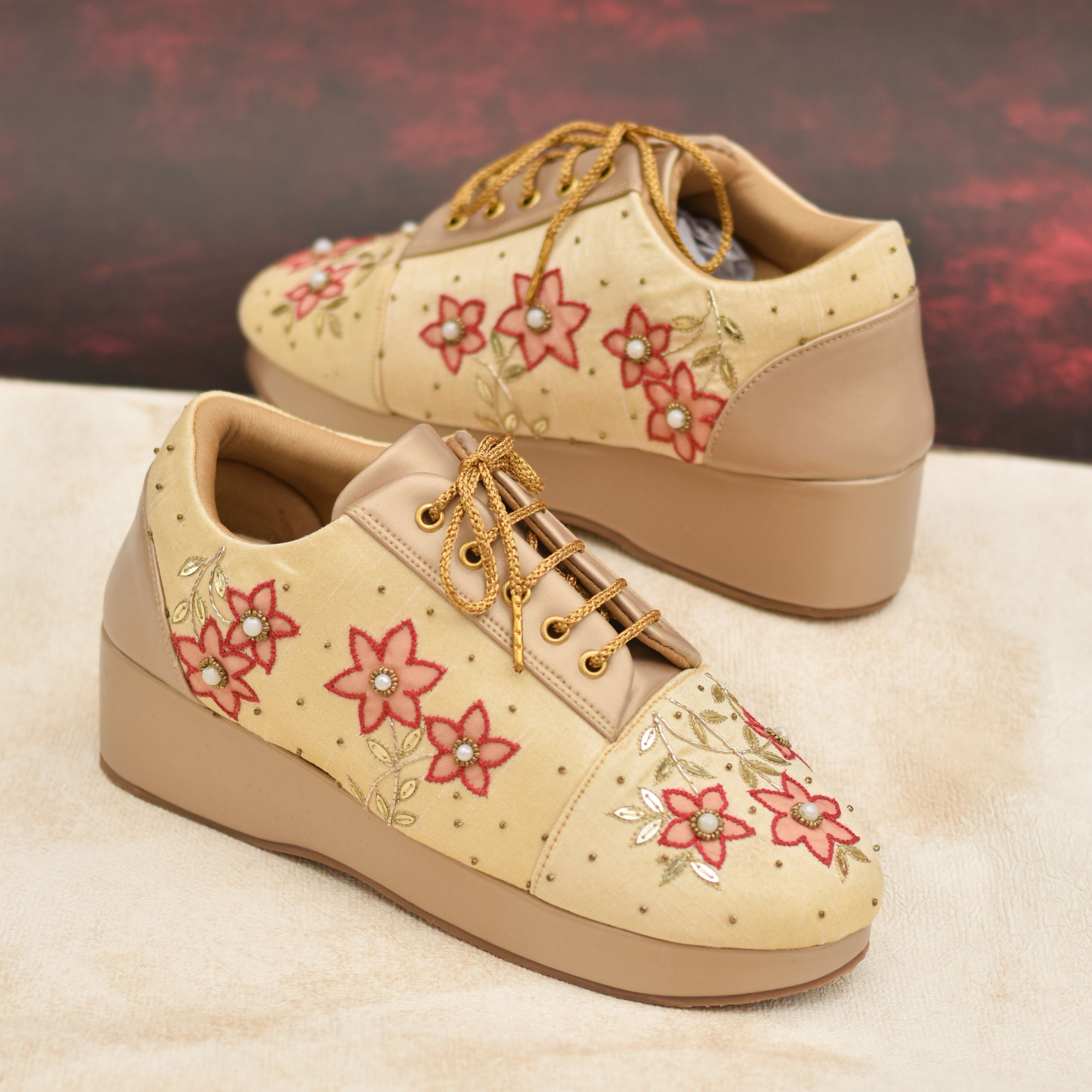 Beige bridal wedge sneakers with peach floral embroidery.