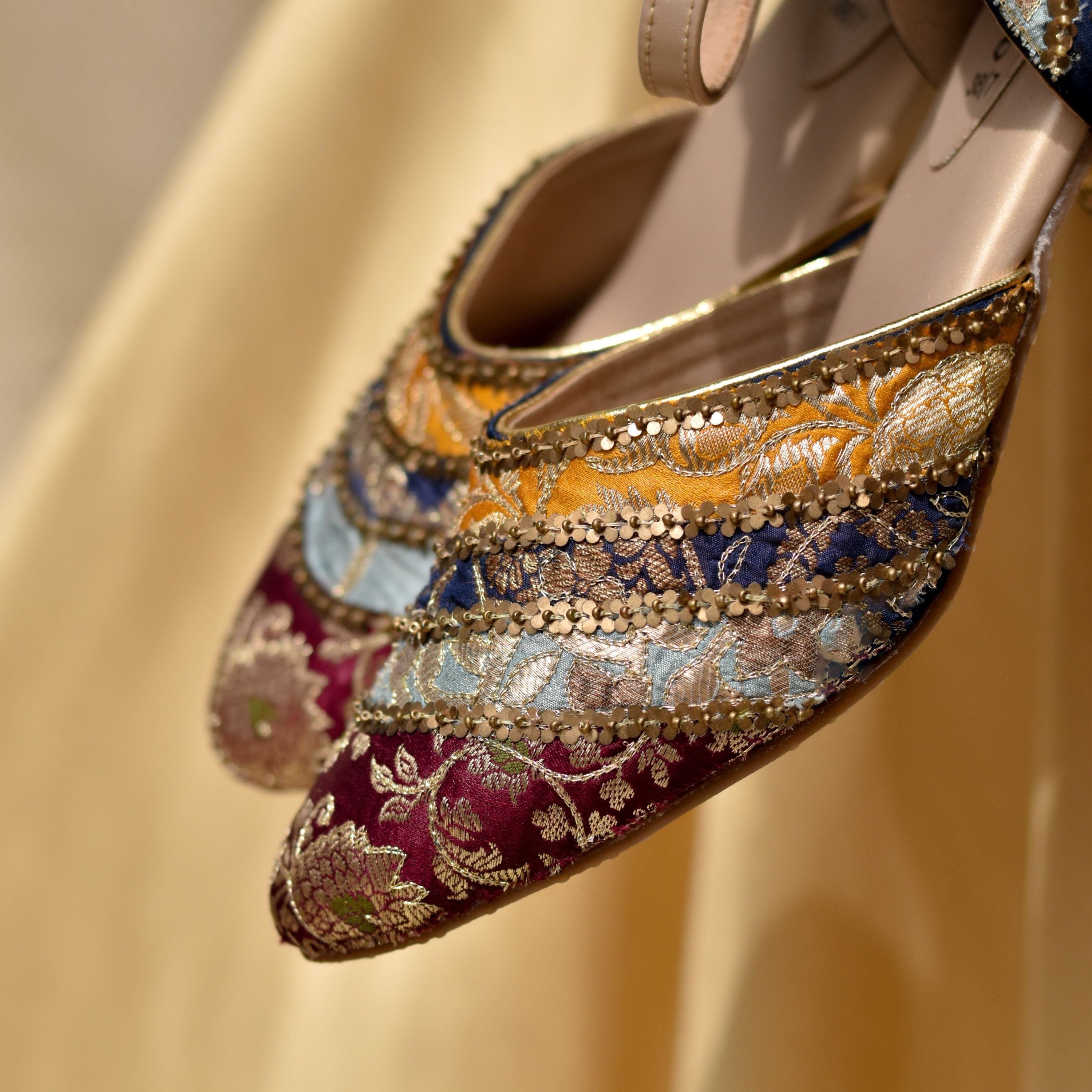 Traditional Indian wedding footwear with colorful striped brocade design