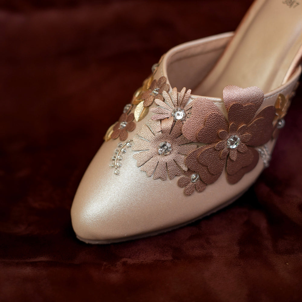 Elegant rose-gold mule with layered floral appliqué and crystal details
