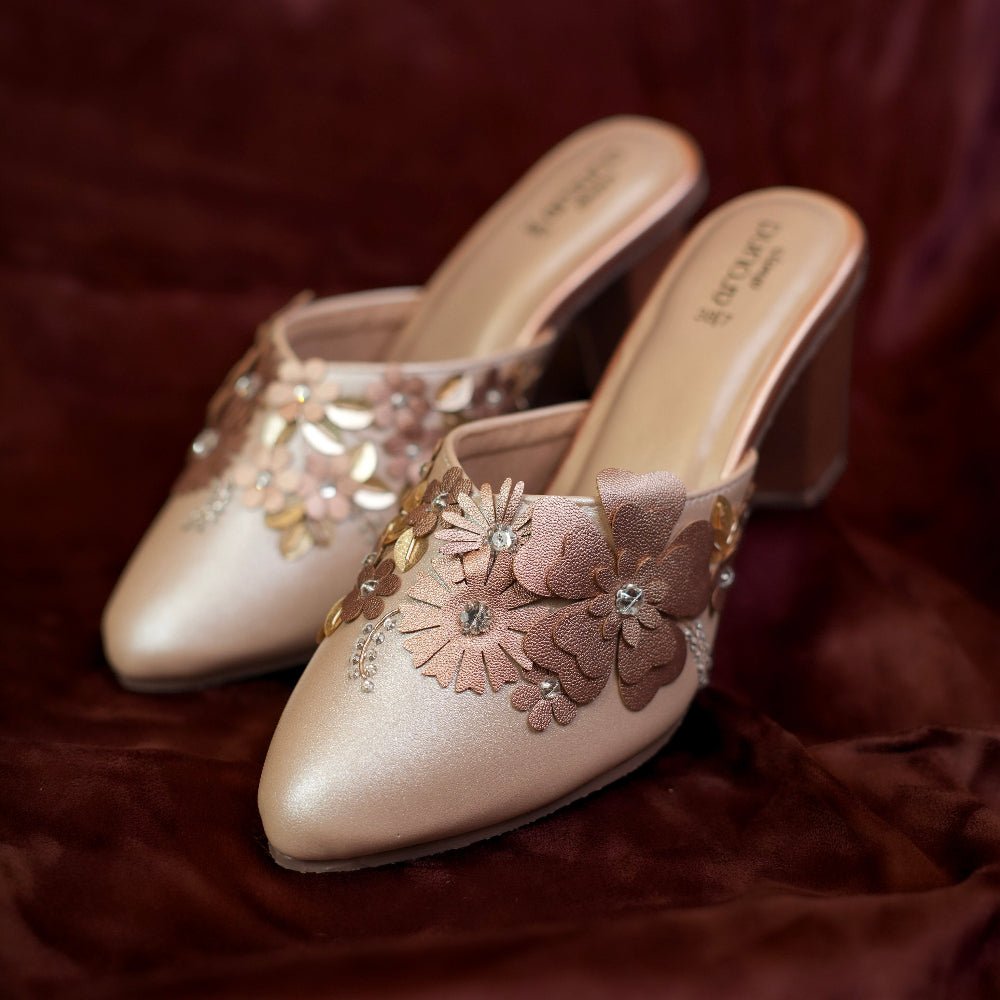 Close-up of floral rose-gold mule with sparkling crystal accents
