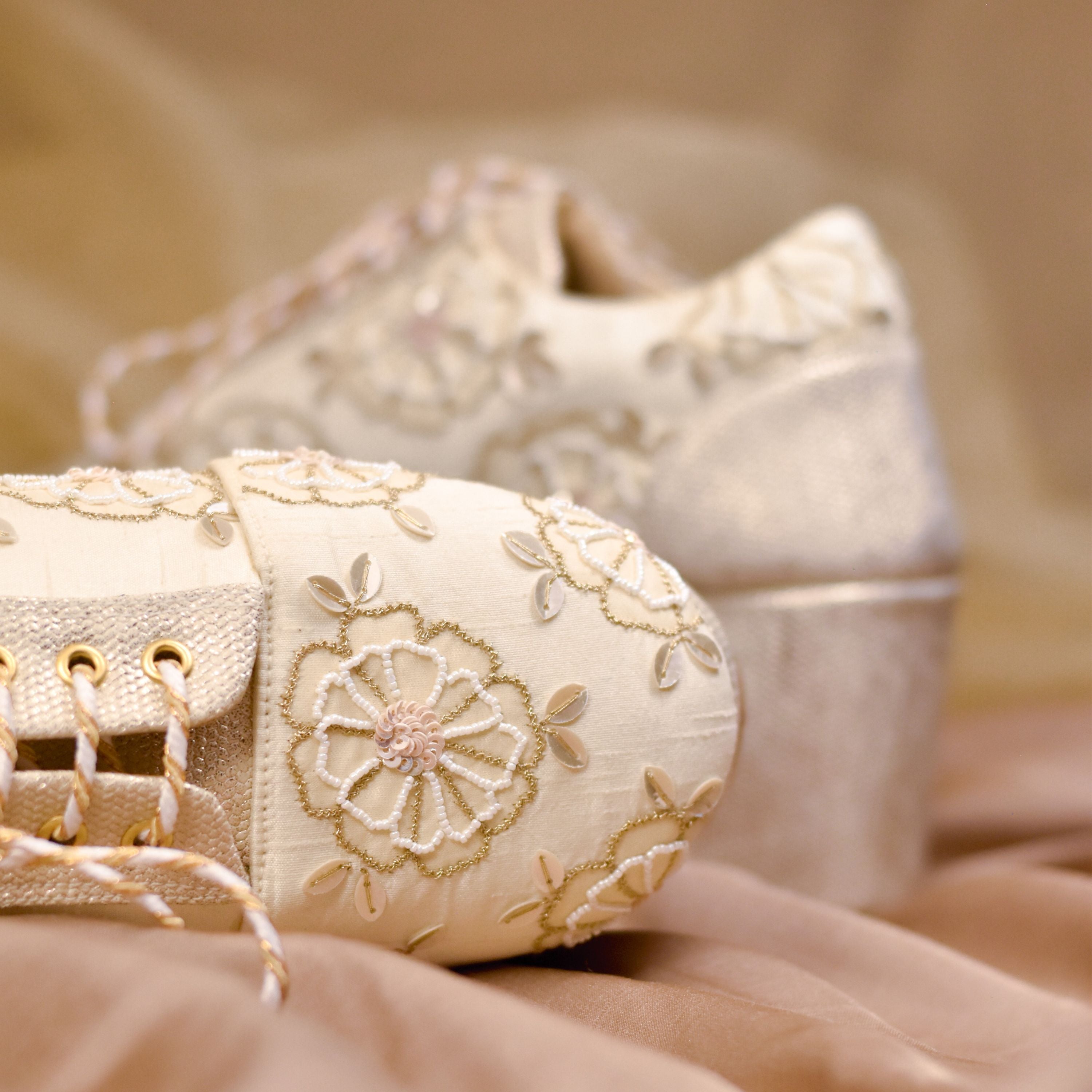 Designer champagne sneakers with floral motifs, sequins, and high platform heel