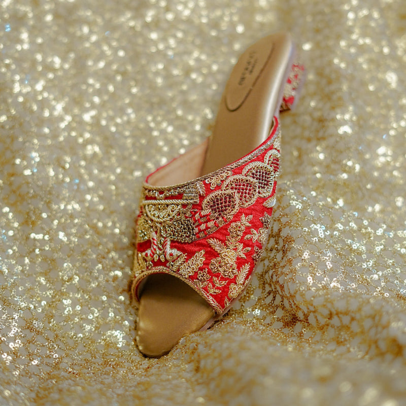 Festive red sandals showcasing threadwork, beadwork, and a decorative heel design