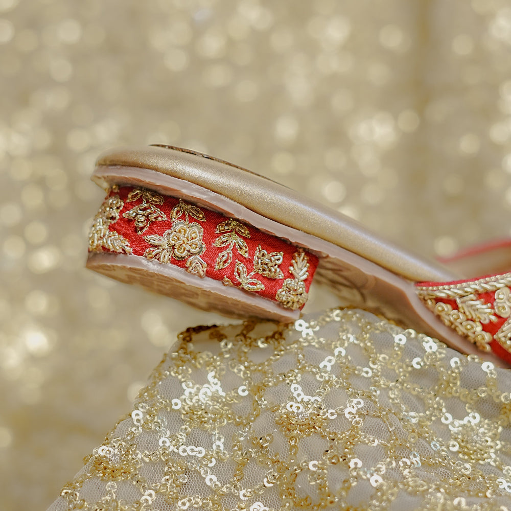 Traditional red sandals enriched with detailed embroidery and ornamental floral patterns