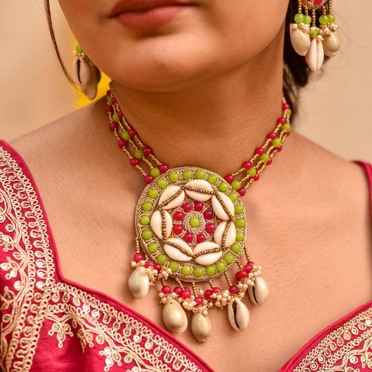 Decorative necklace with rani, green, and white beads and kauri shells for haldi