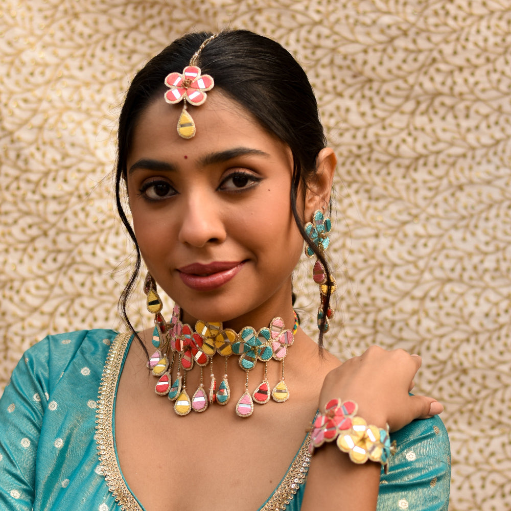Bride wearing colorful mirror work jewelry for an Indian wedding celebration