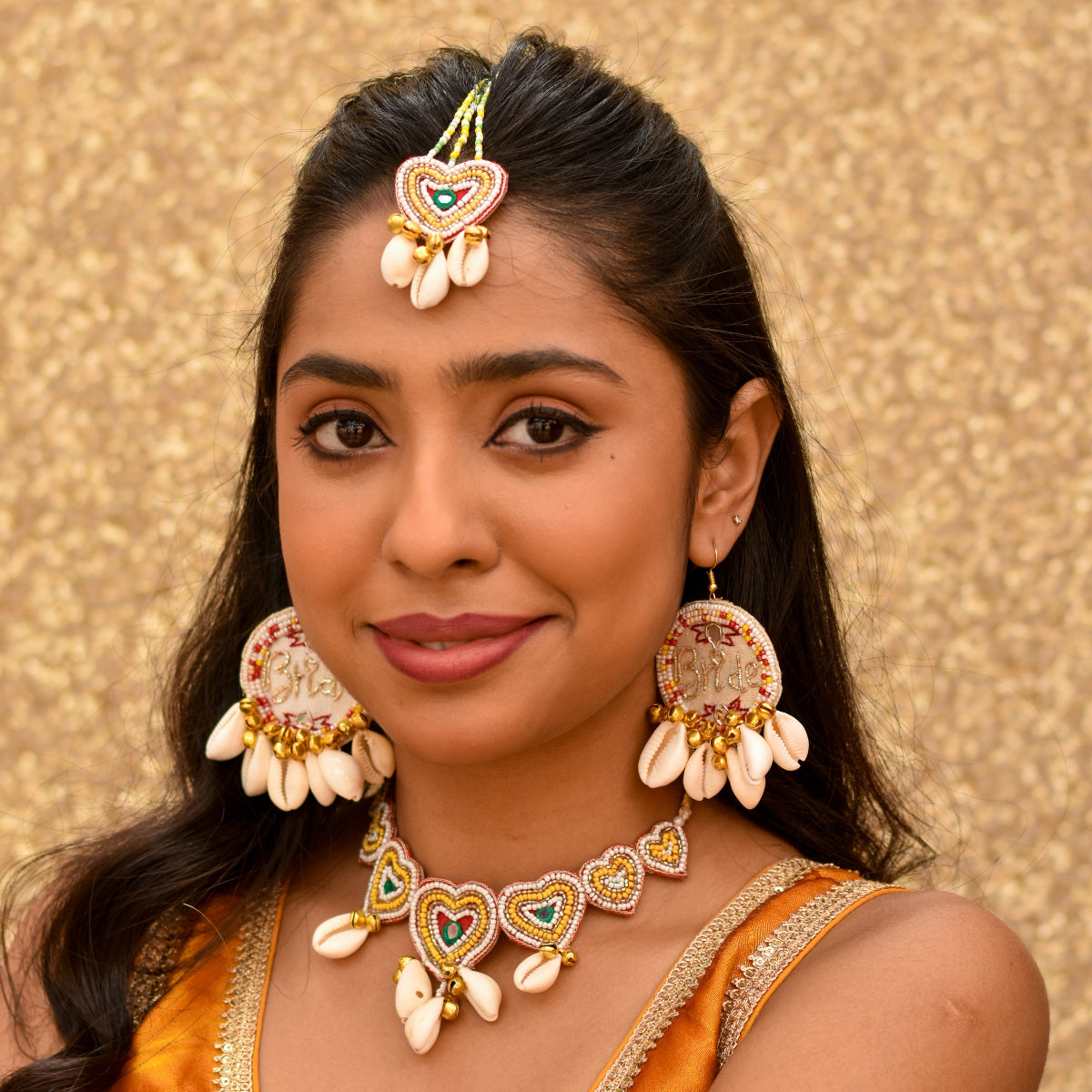 White bridal earrings for haldi with golden zardozi text saying Bride