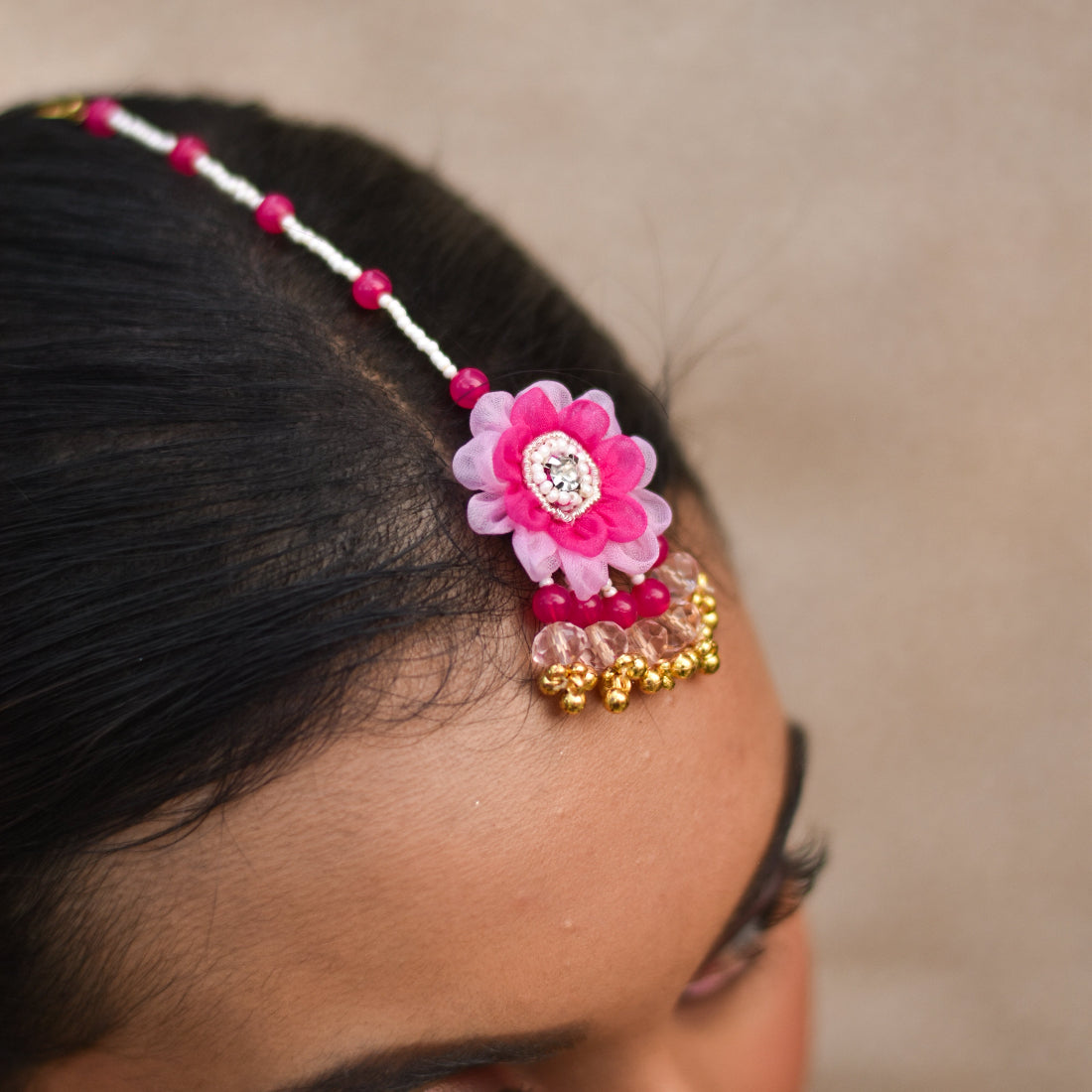 Pink organza based maangtika with ghunghroo drops for a premium haldi look