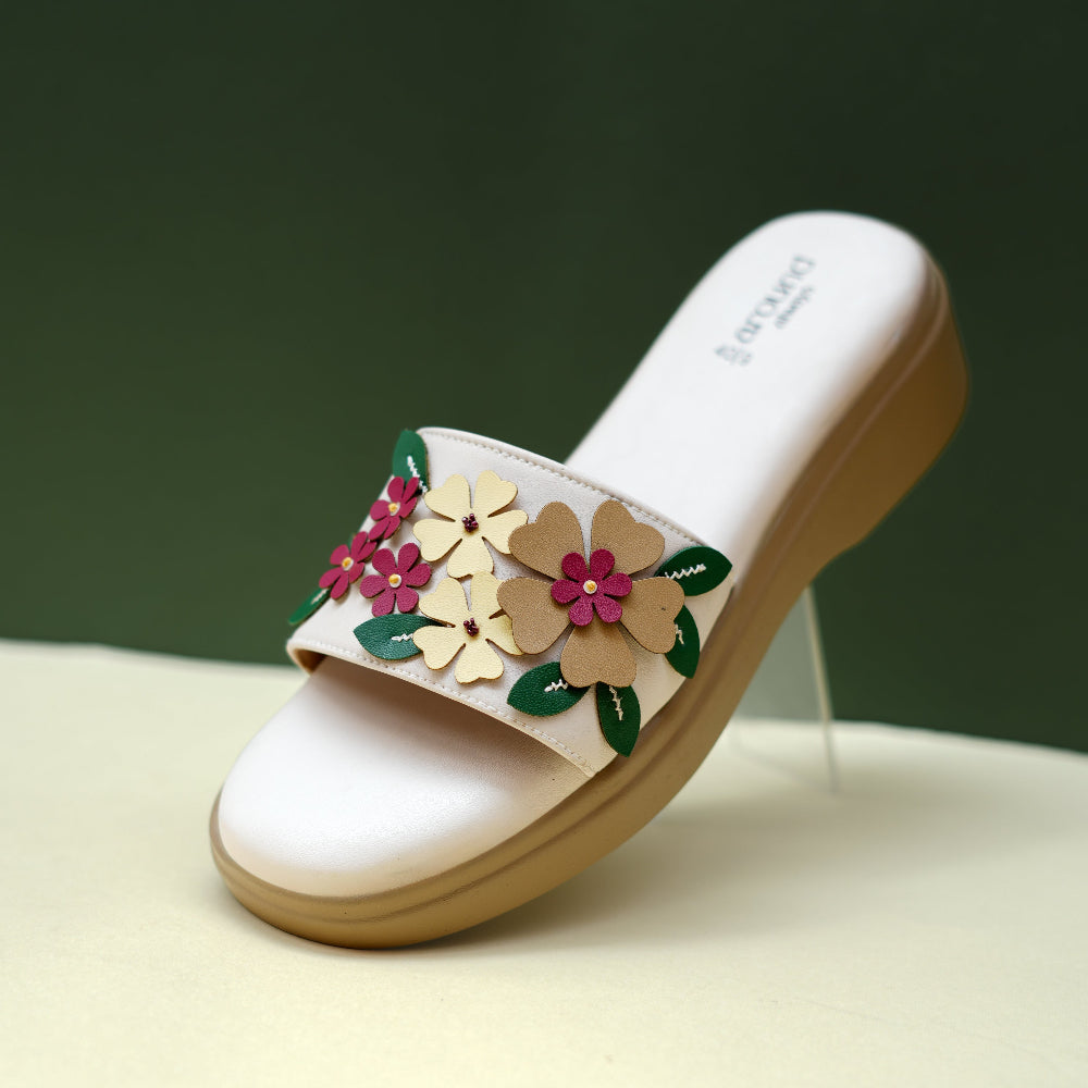 White sandal with colourful flowers and green leaf details
