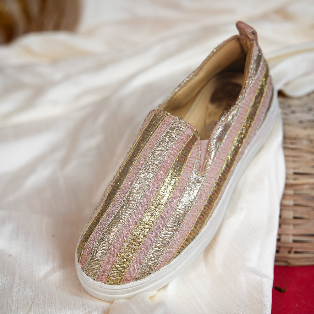 Blush pink sneaker with gold and silver metallic stripe detailing
