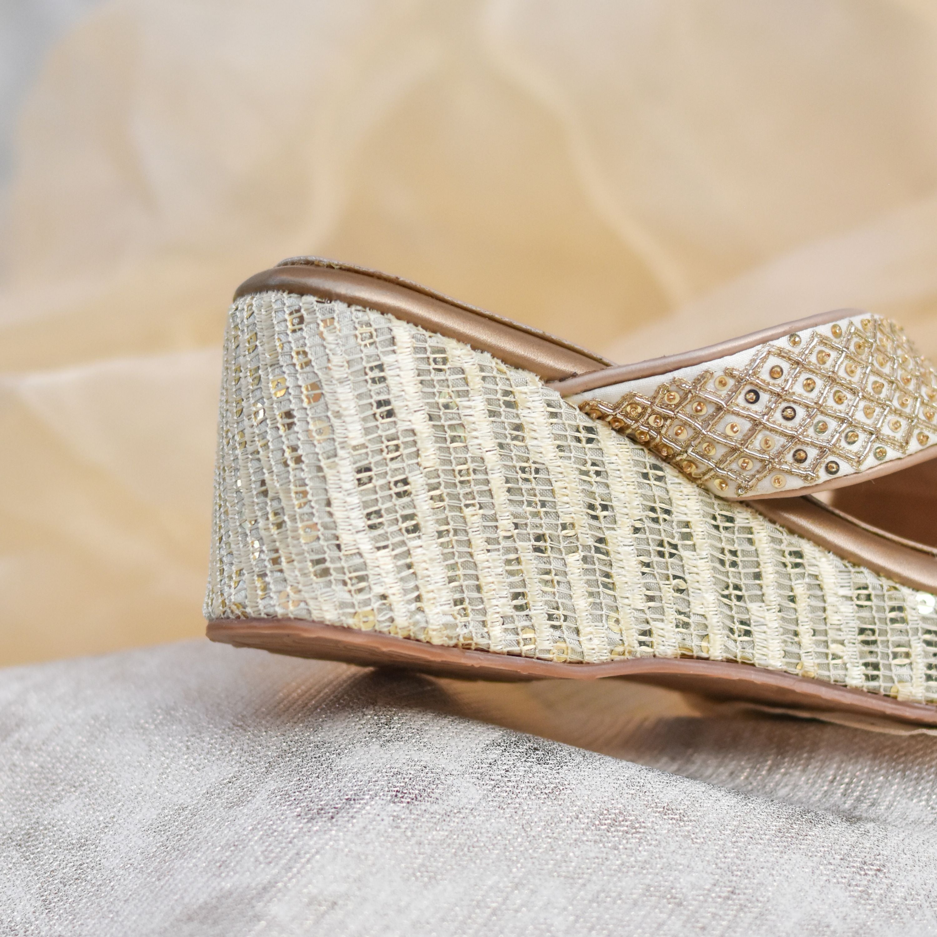 Festive wedge sandals with cross straps and hand-detailed shimmer work.