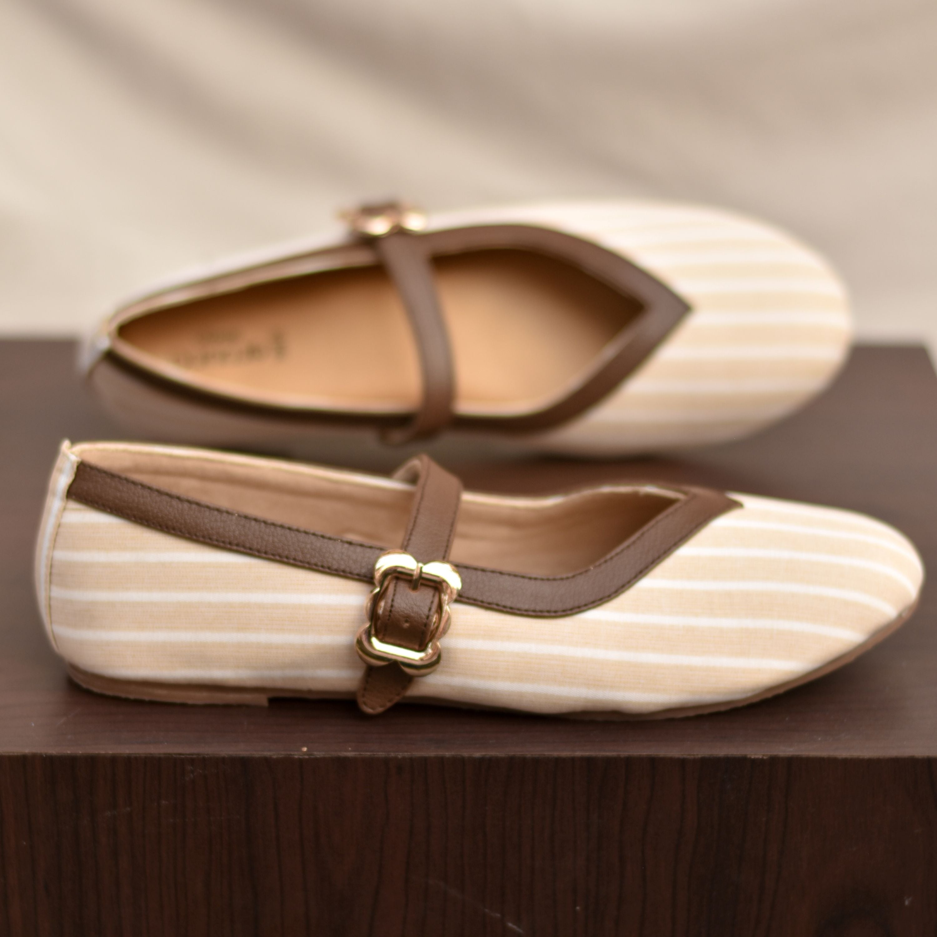 Cream striped Mary Jane shoes with pointed V-cut topline and brown edging.