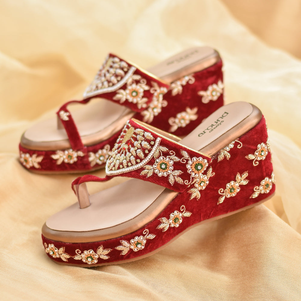 Festive red wedge heels with traditional floral and peacock motif.