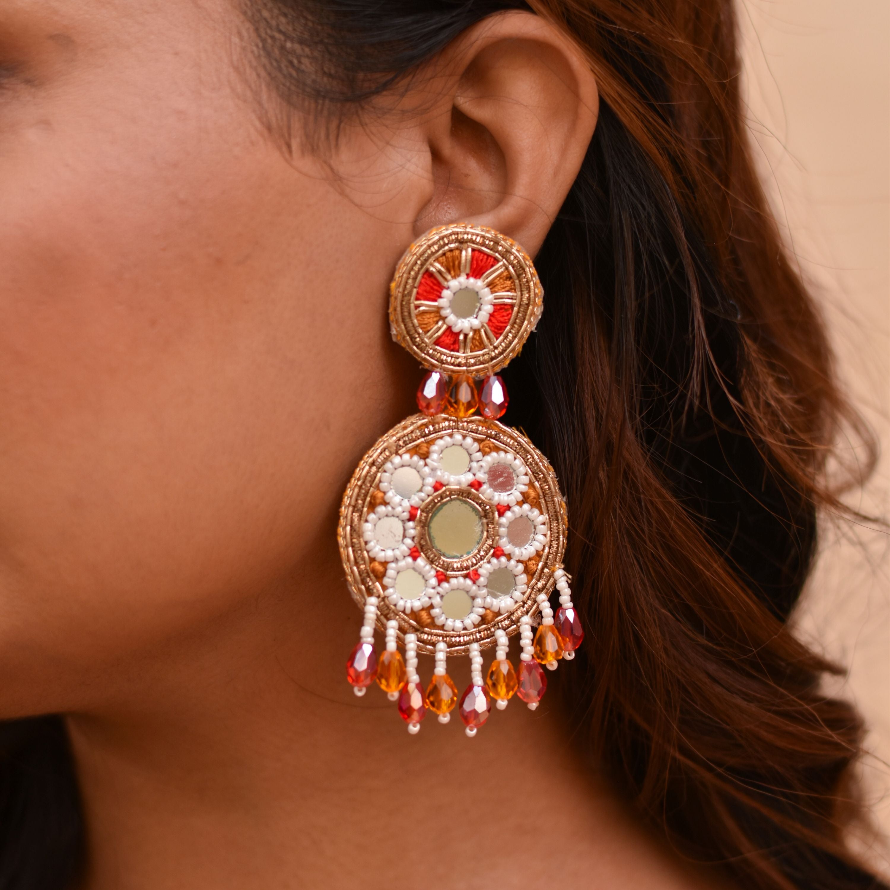 Earring with intricate embroidery with pearls, mirrors and colorful beads.