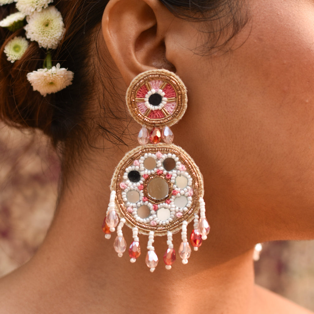 Bride wearing a pastel earring with beads and floral hair accessory