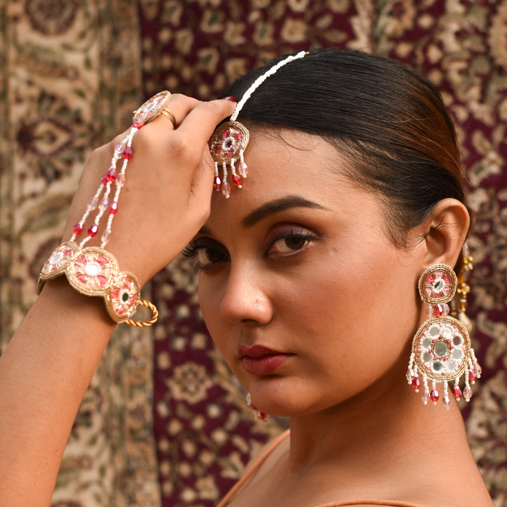 Bride wearing decorative earrings and hathphool for her pastel haldi look