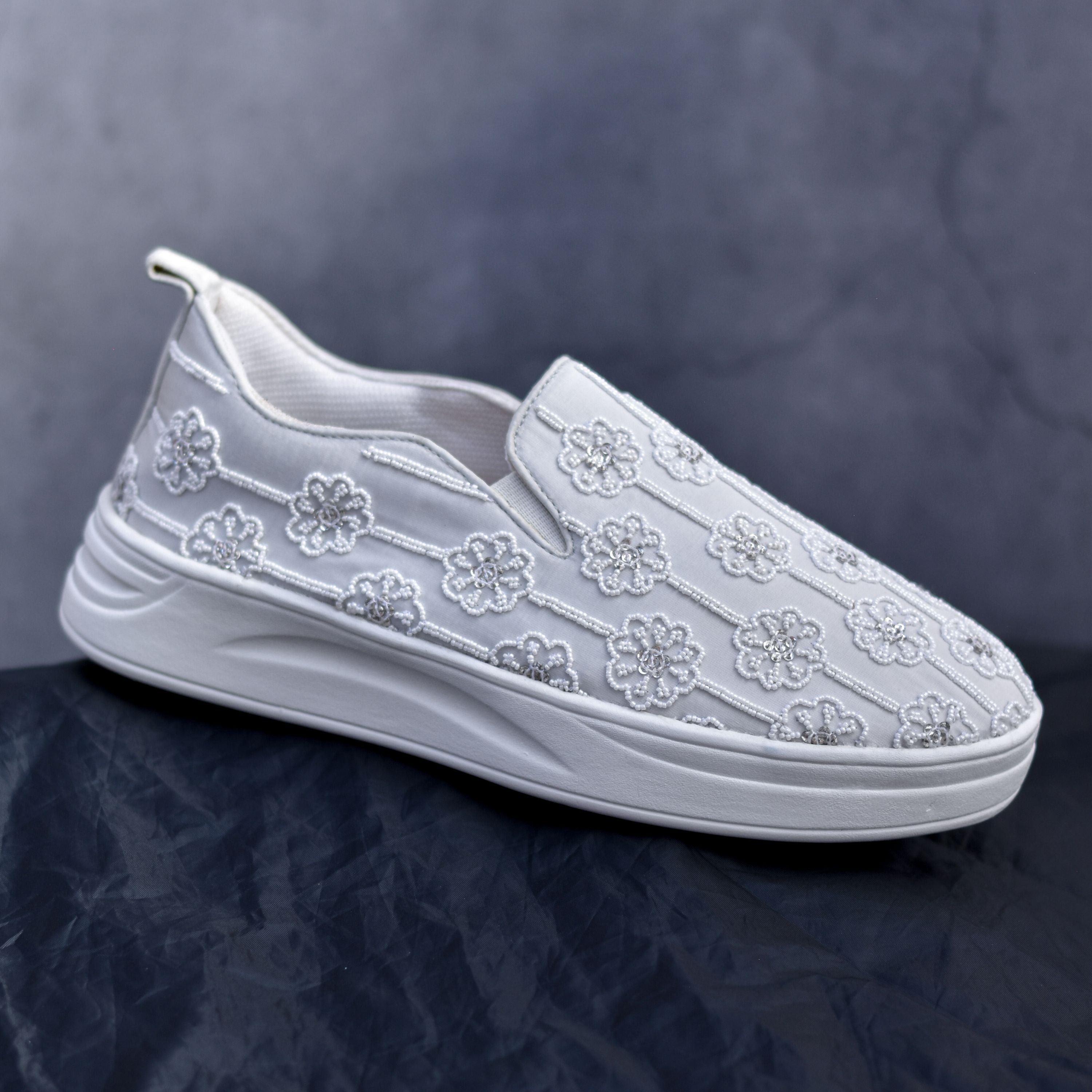 Designer ethnic sneakers in white with hand-stitched flower patterns.