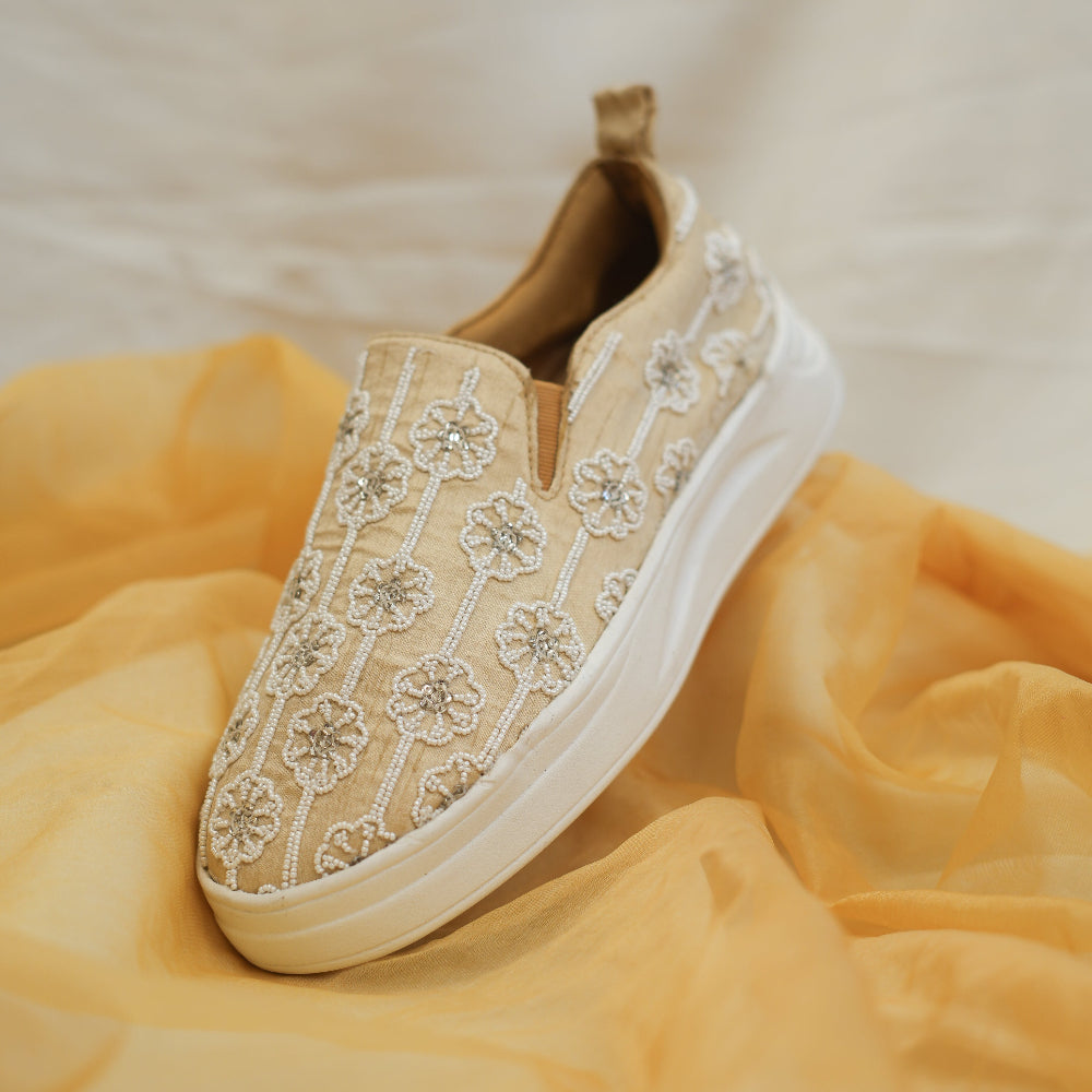 Champagne textile sneakers with delicate floral motifs and vertical patterns

