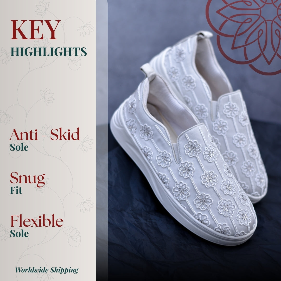 White slip on with delicate floral embroidery, snug fit, and flexible anti skid sole for everyday comfort.
