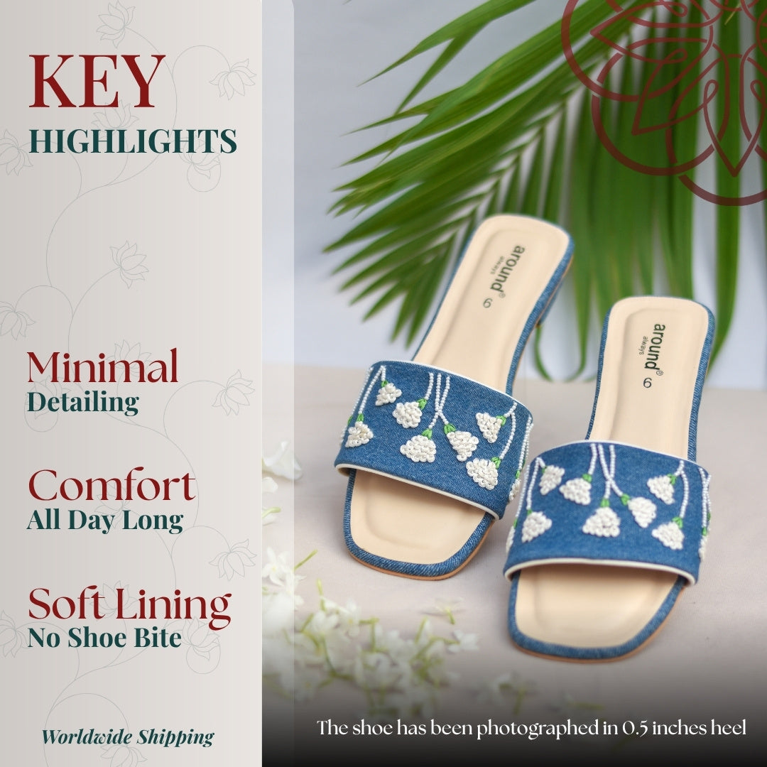 Embroidered denim slip on sandals featuring delicate white flower detailing