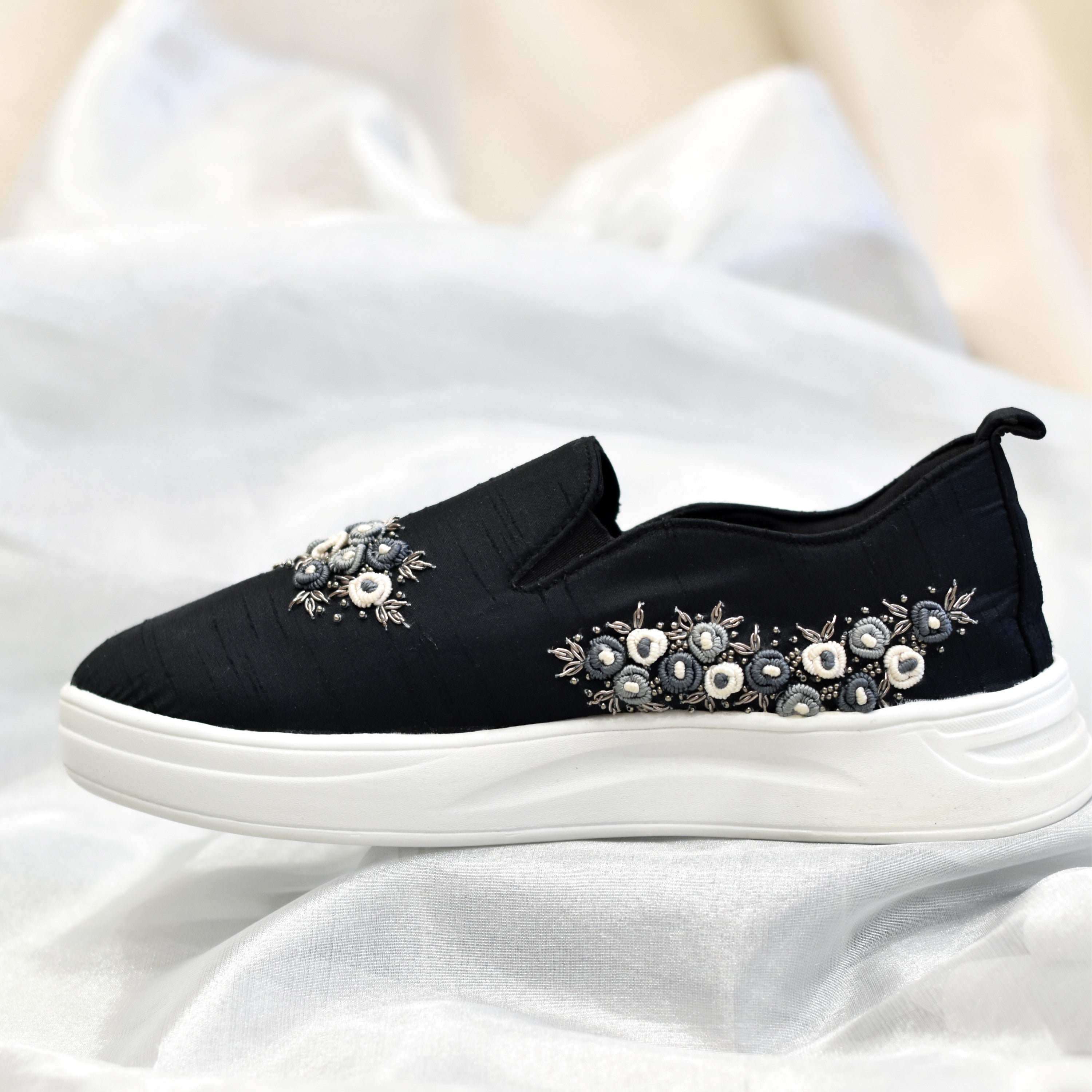 Modern indo-western sneakers with a black base and contrasting floral embroidery