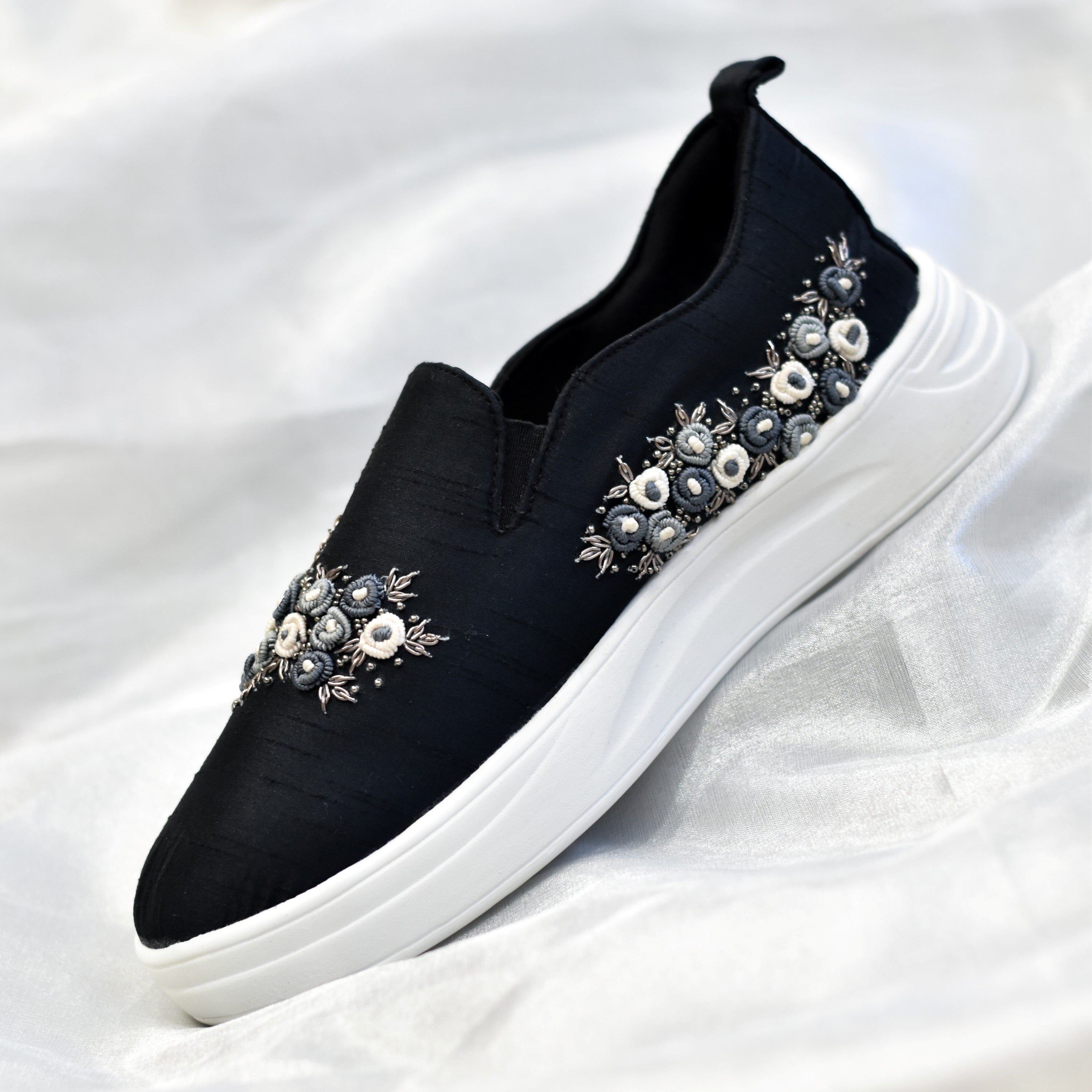 Black slip-on sneakers for women with floral embellishments of thread and zardozi