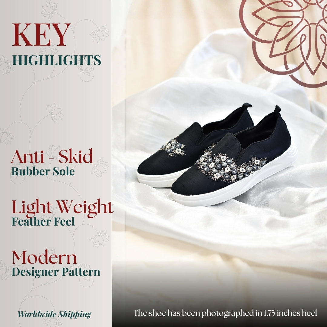 Black slip on sneakers with pearl and crystal embellishment, cushioned sole and lightweight anti skid design for everyday wear