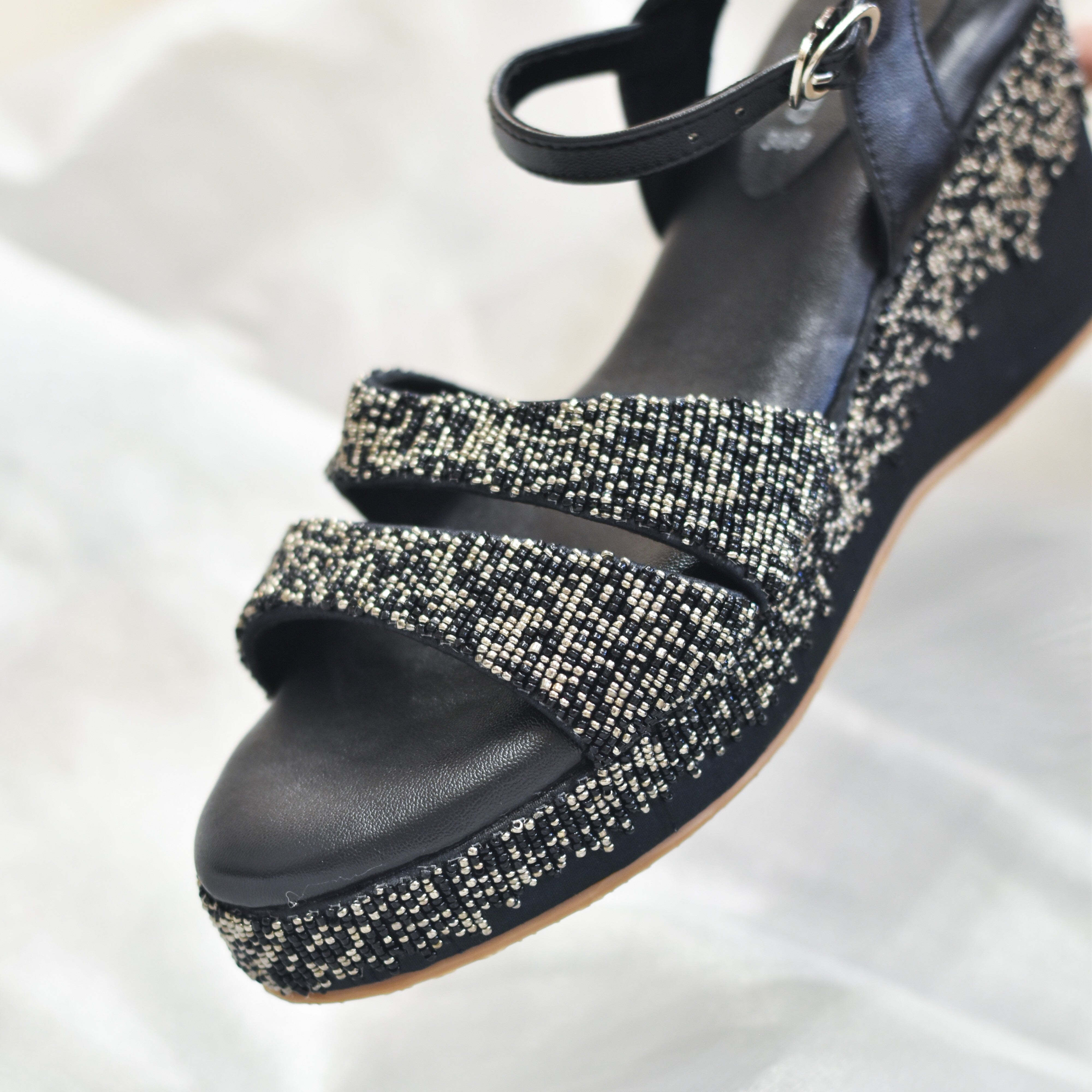 Black sandal wedges in sleek front strap and back buckle support