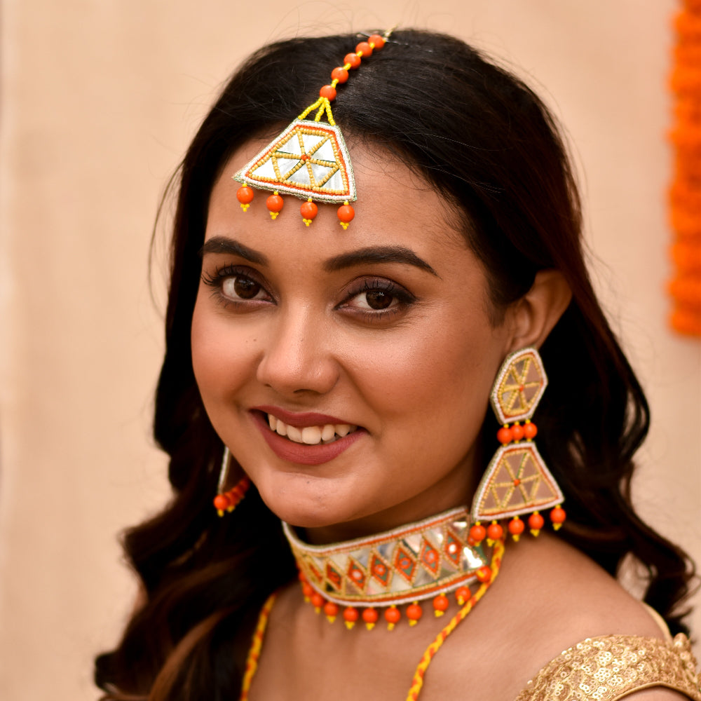 Indian bride wearing handmade haldi jewellery set with earrings maangtika and choker