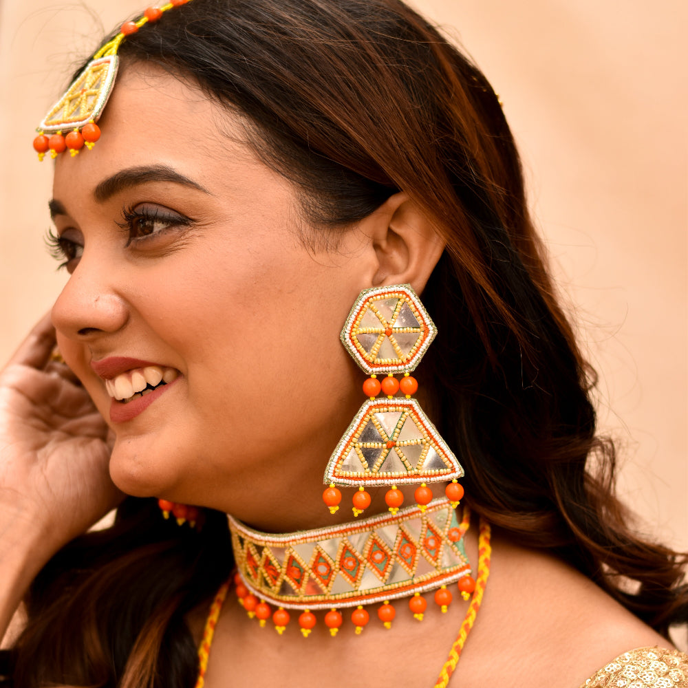 Indian bridesmaid wearing trending haldi jewellery set with earrings, choker and maangtika 