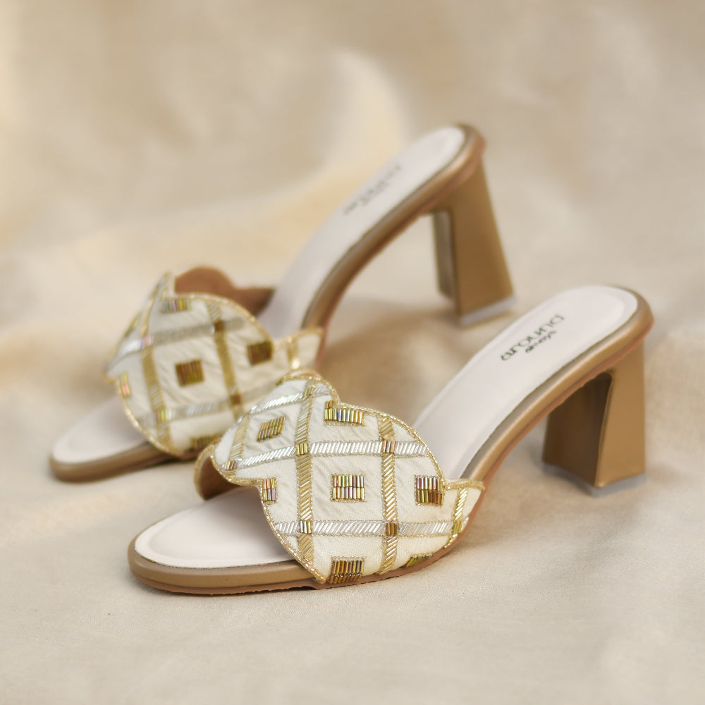 Ivory-gold heels with grid pattern and wavy front strap.