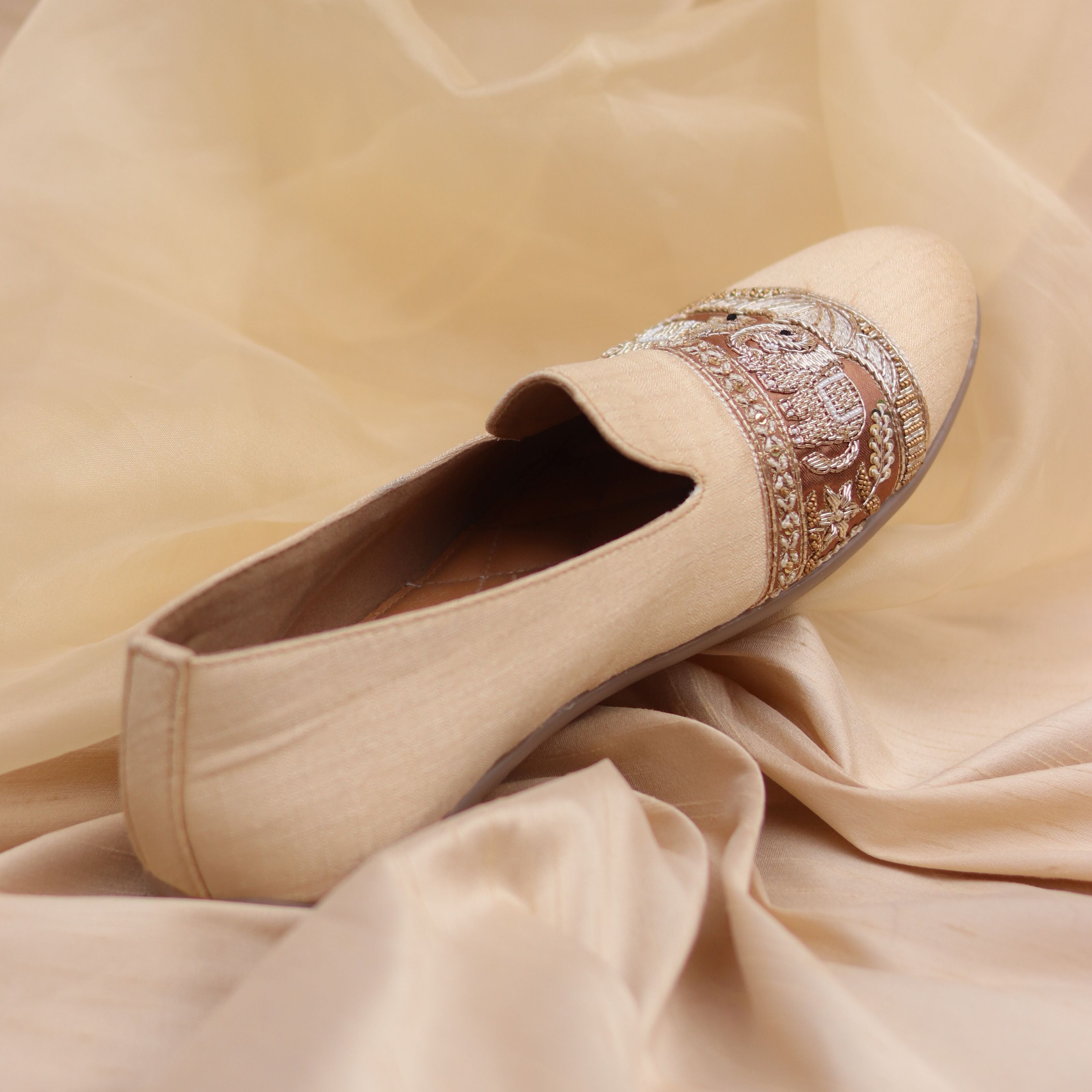 Men’s beige shoes with detailed elephant and foliage design in rich threadwork.