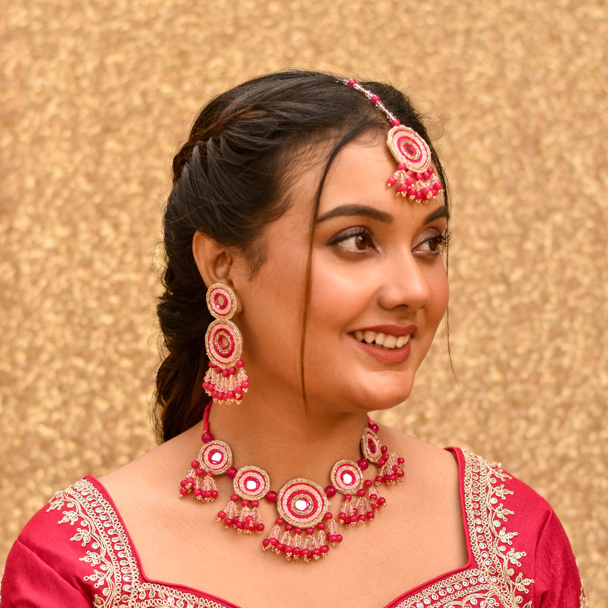 A bride looking radiant in her pink beaded jewellery set for haldi  