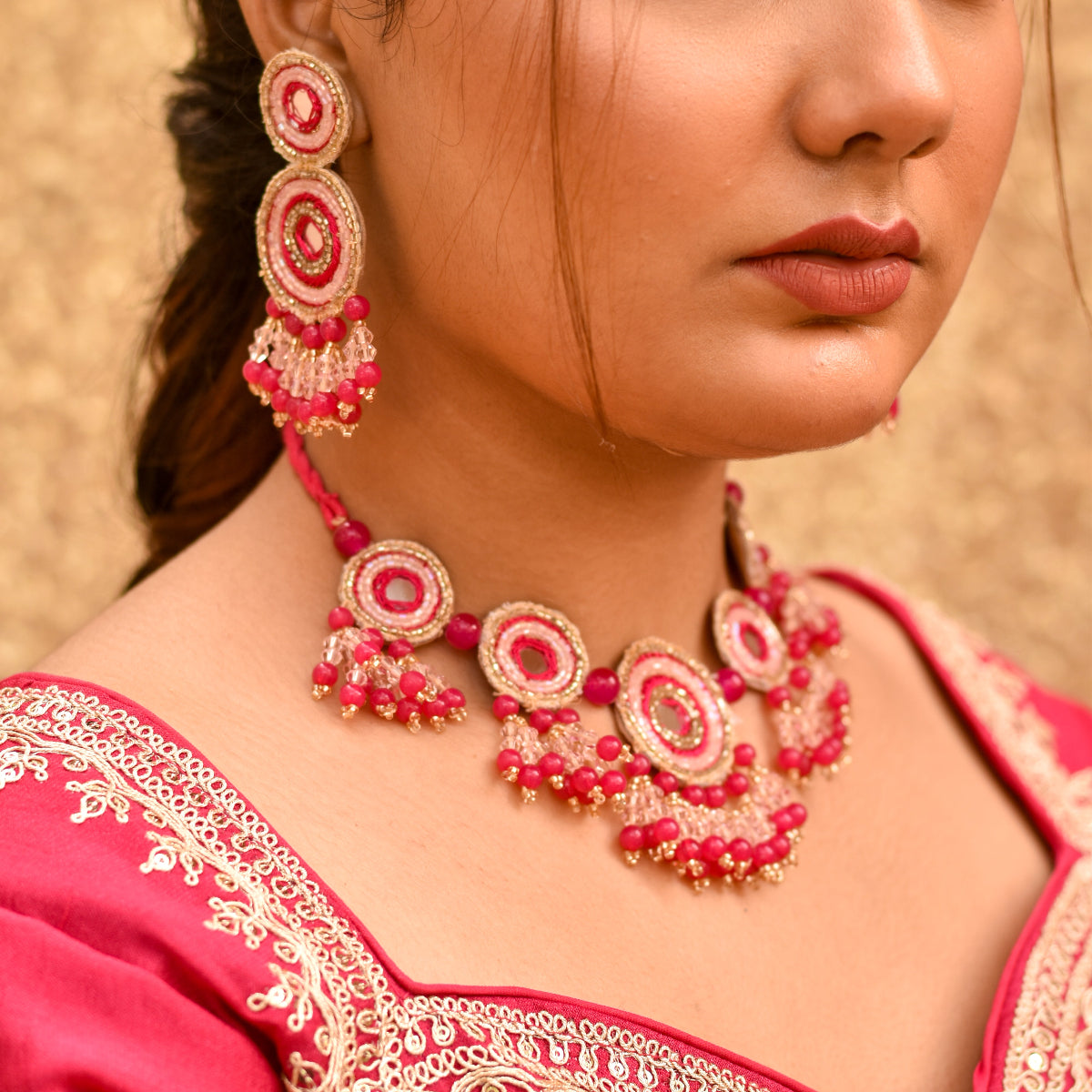 Bride wearing a pink beaded necklace and earrings on a pink haldi blouse