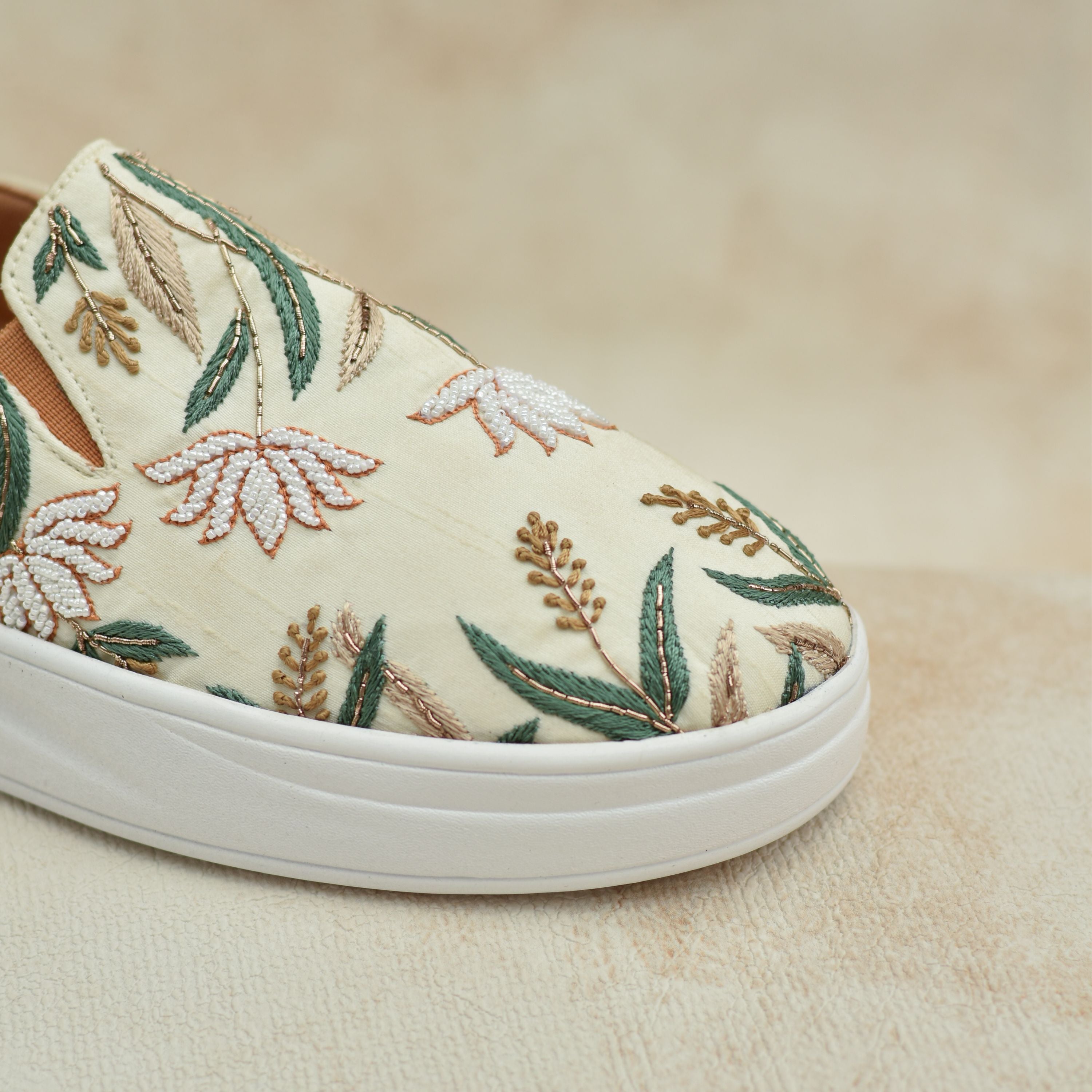 Comfortable women’s sneakers with hand-stitched white florals and greenery.