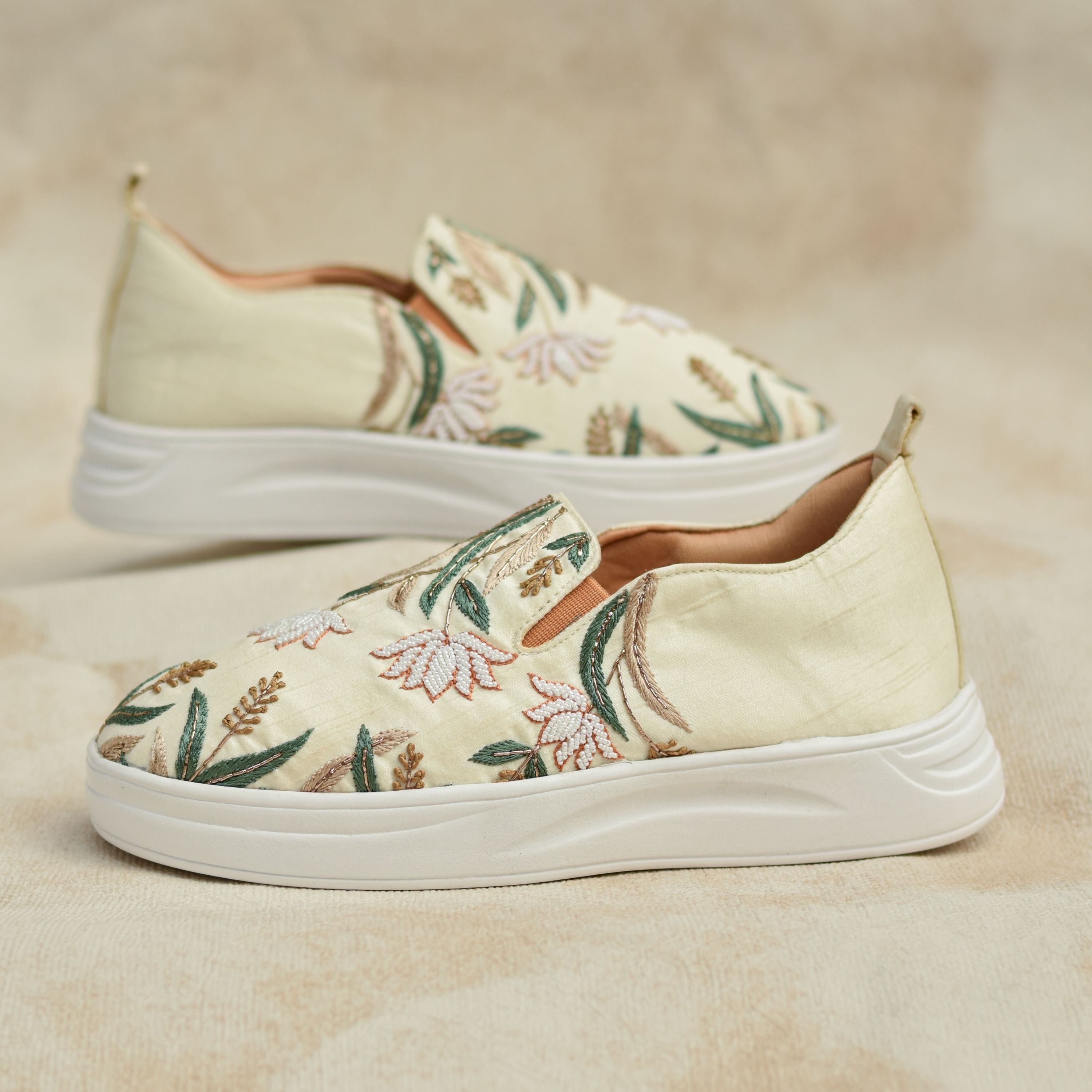 Nature-inspired designer sneakers with floral patterns and cushioned white sole.