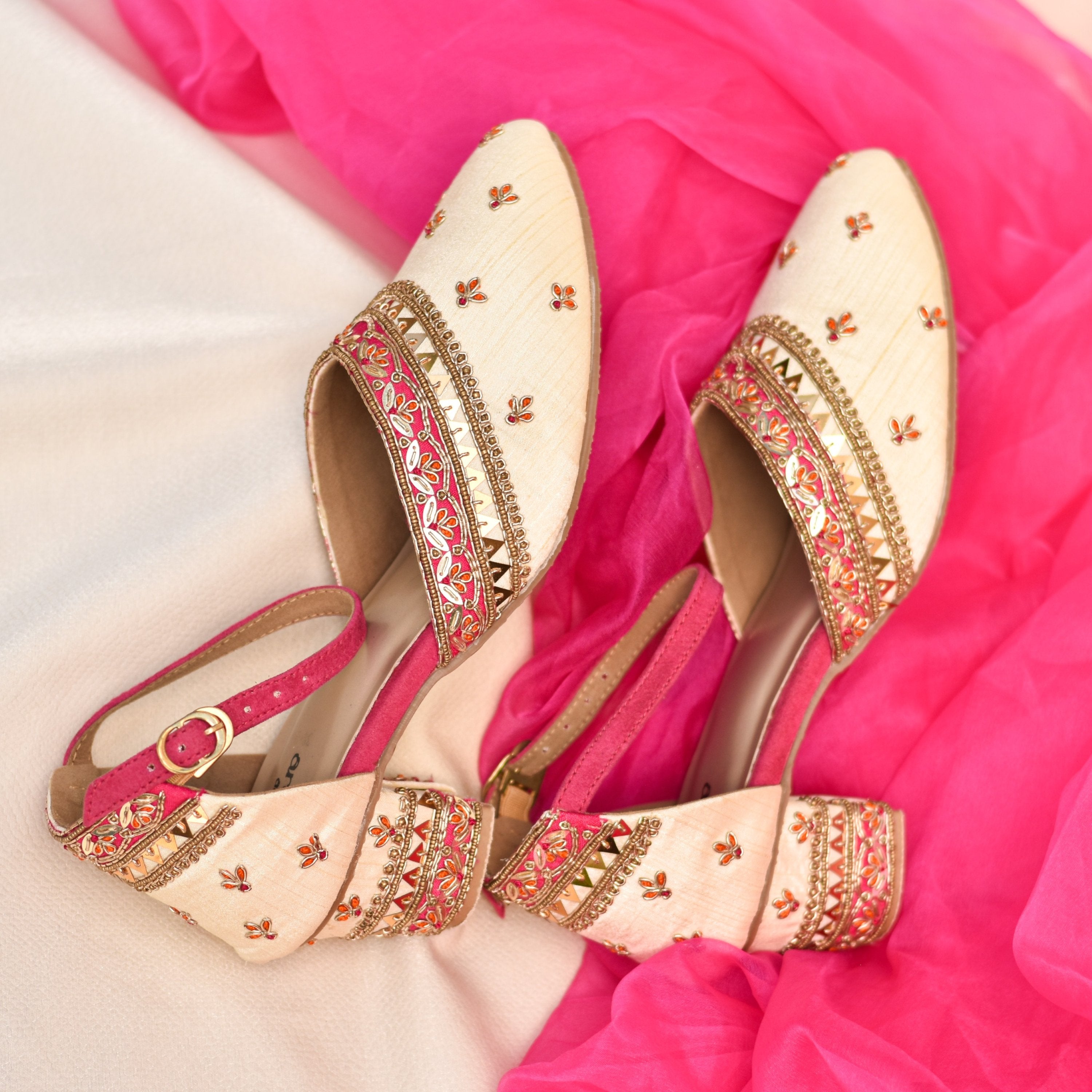 Pair of ornate shoes with gold and pink embellishments for wedding sarees and lehenga