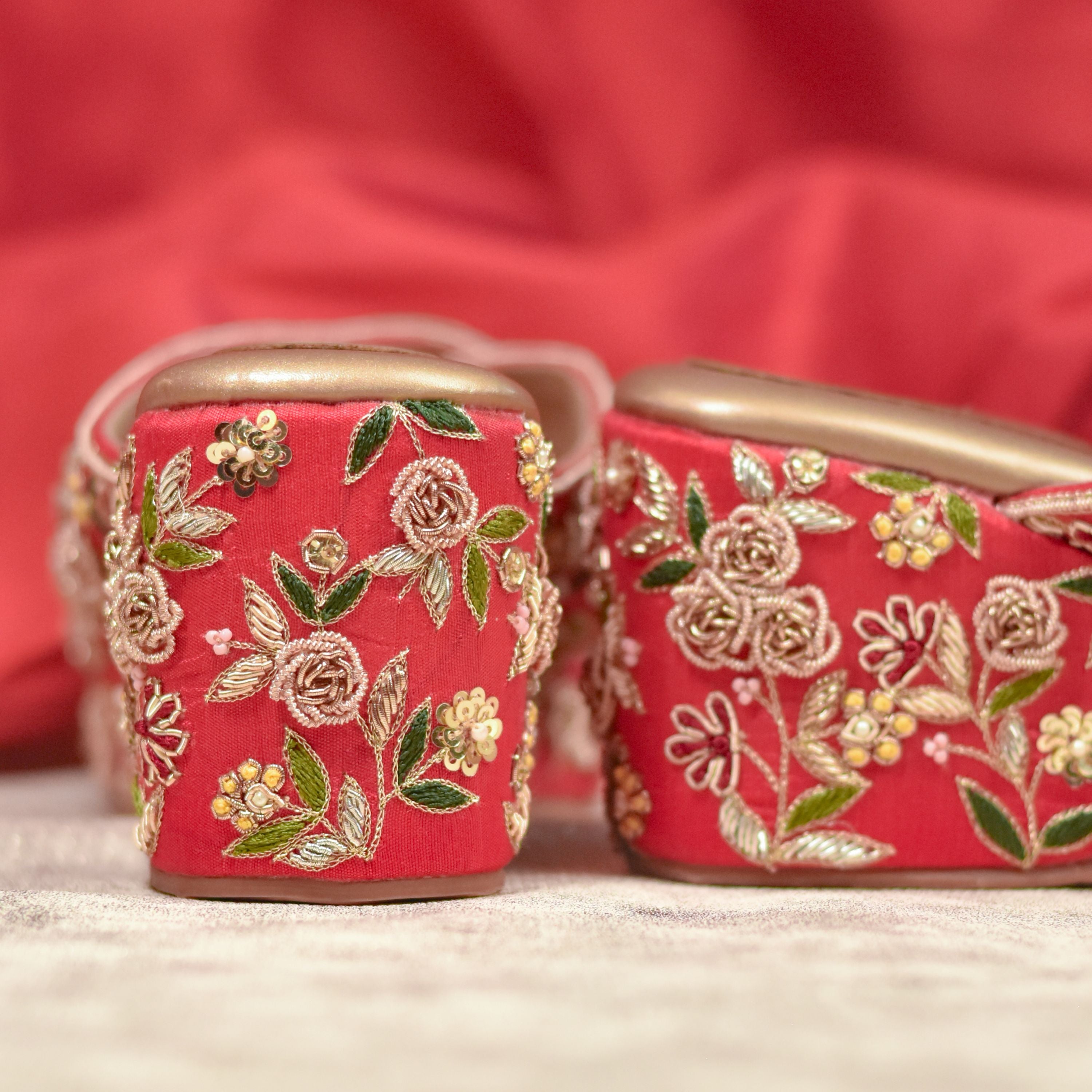 Embellished red wedding wedges with golden and green flowers.