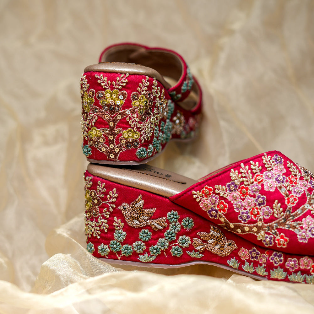 Maroon crossover wedge sandals with handcrafted floral patterns and detailed side work