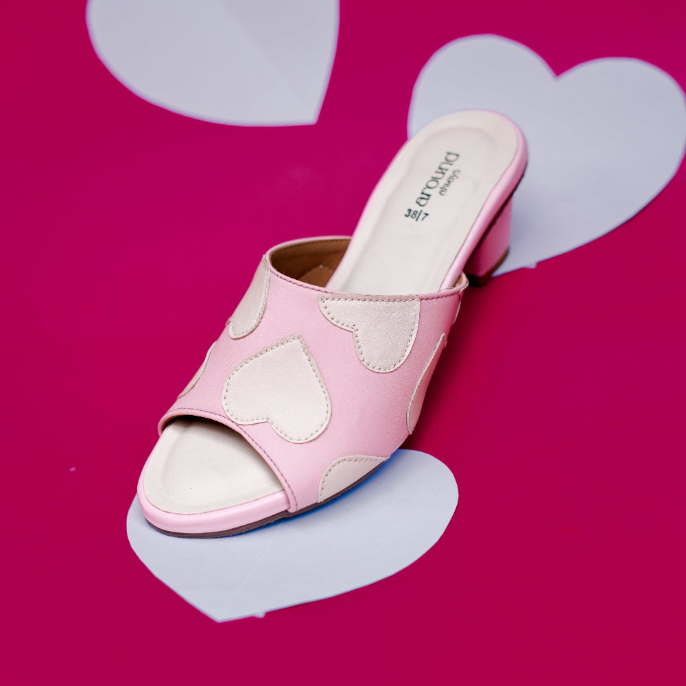 Blush pink open-toe mule decorated with cream heart motifs
